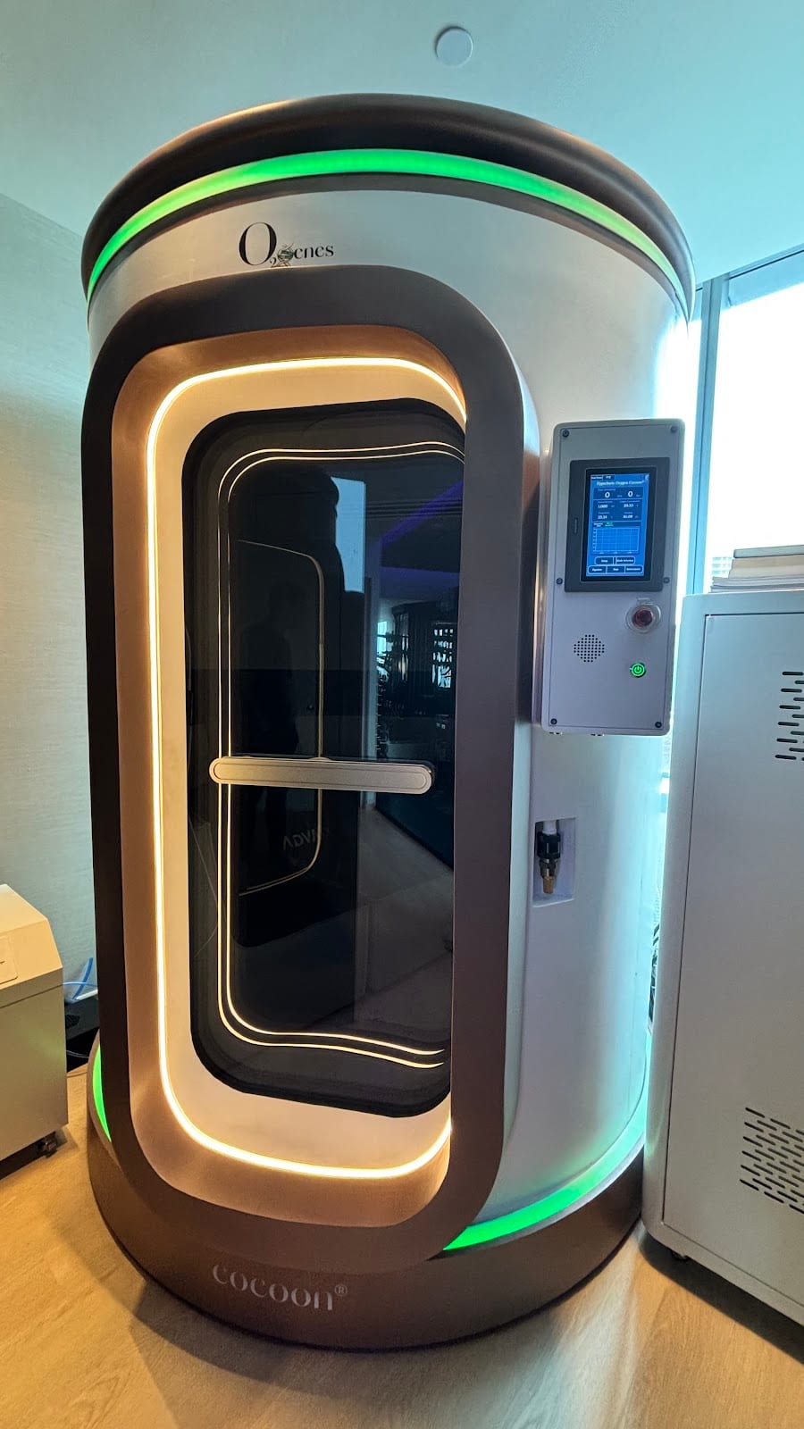 The hyperbaric oxygen chamber at Asia Longevity, a white capsule lit with warm and green light